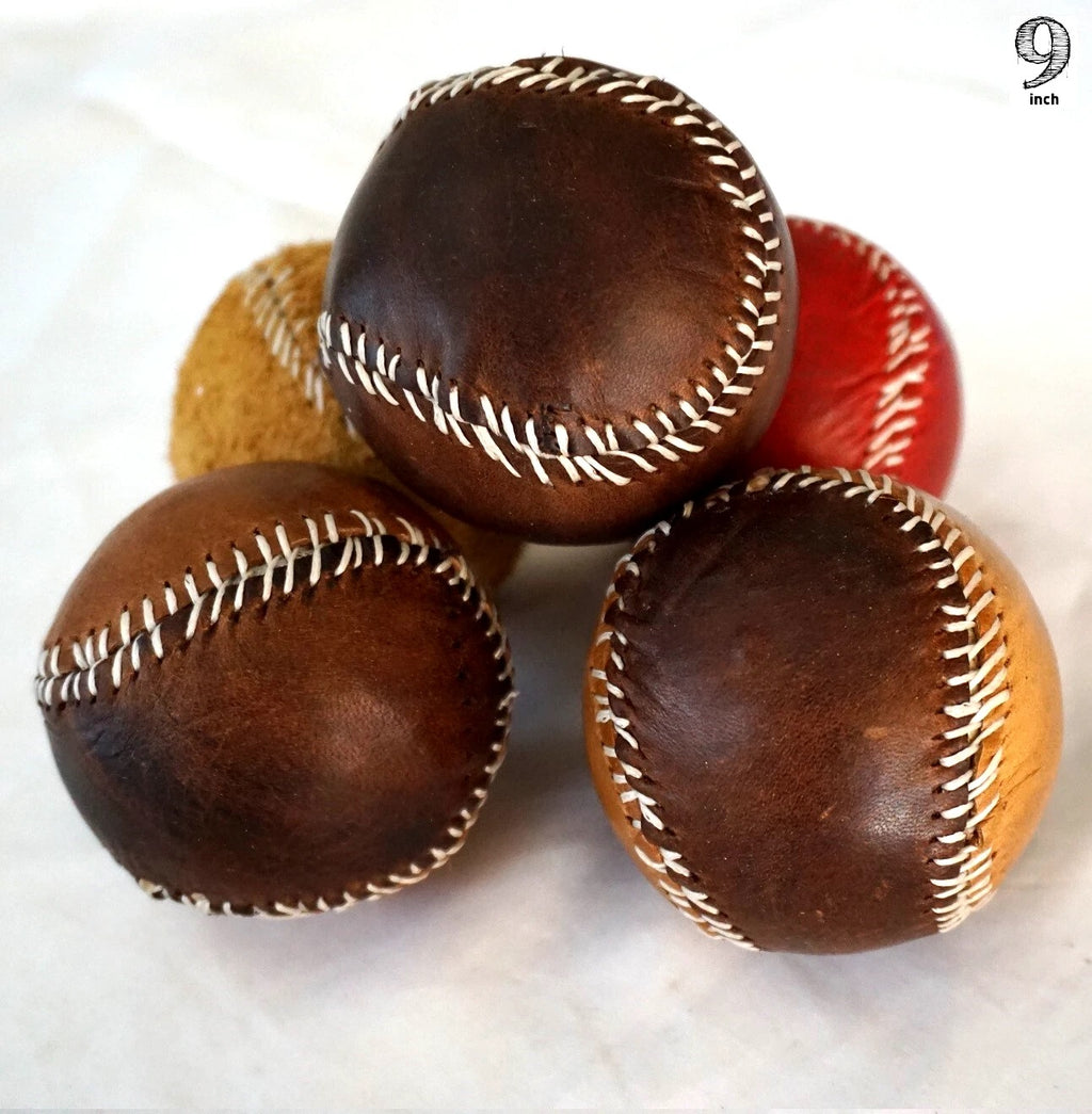 Handmade vintage red leather baseball with stitching, crafted with thread and needle by DAVISCASE, showcasing detailed craftsmanship.