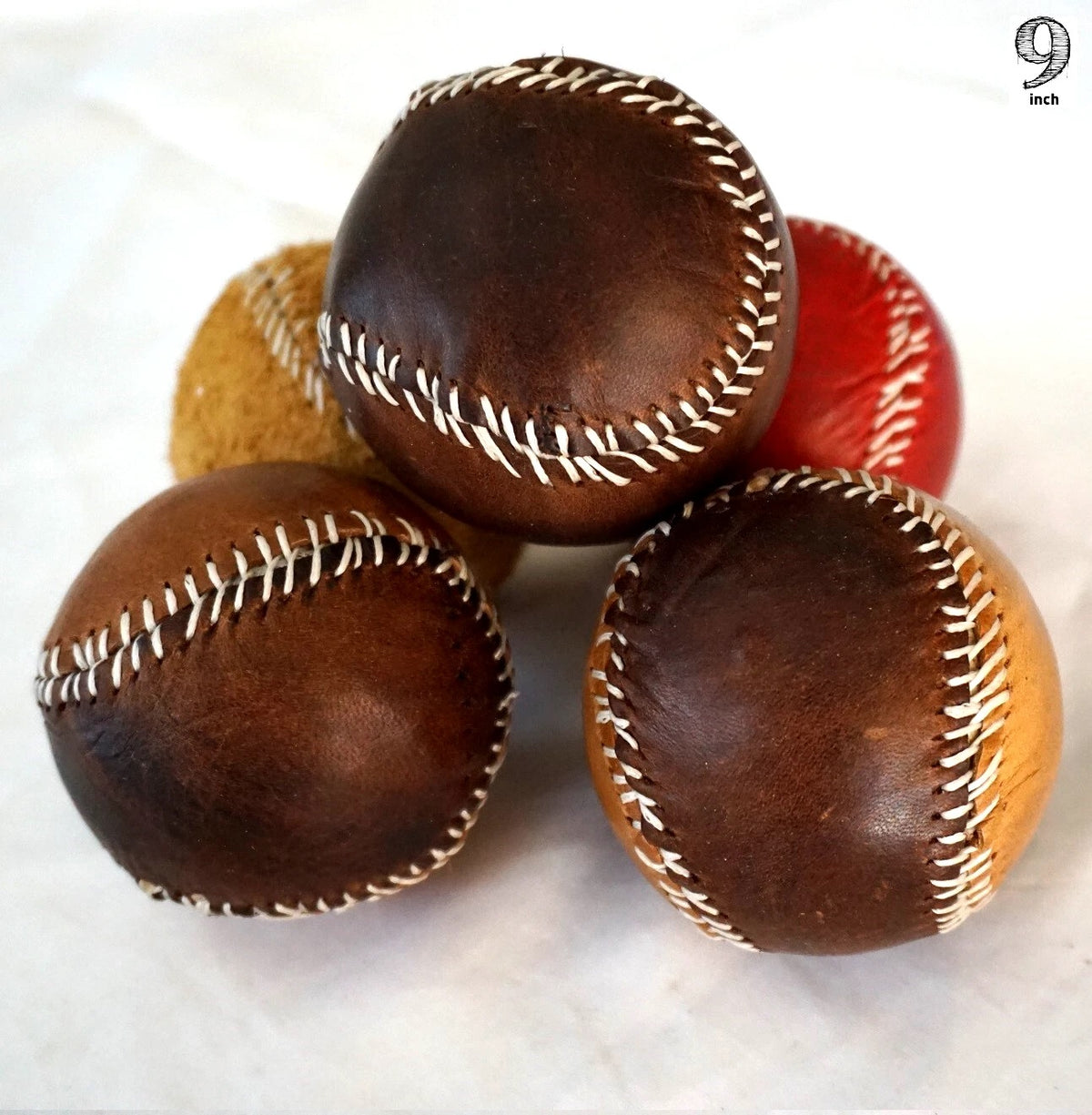 Handmade vintage red leather baseball with stitching, crafted with thread and needle by DAVISCASE, showcasing detailed craftsmanship.