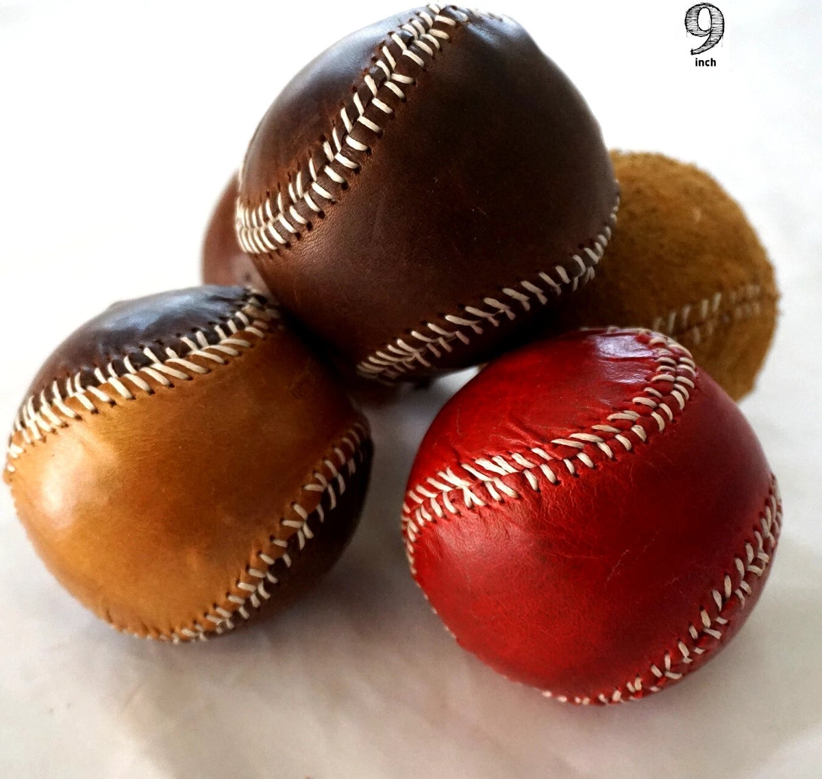 Handmade vintage red leather baseball with stitching and thread, crafted by DAVISCASE, showcasing detailed hand-sewn craftsmanship.
