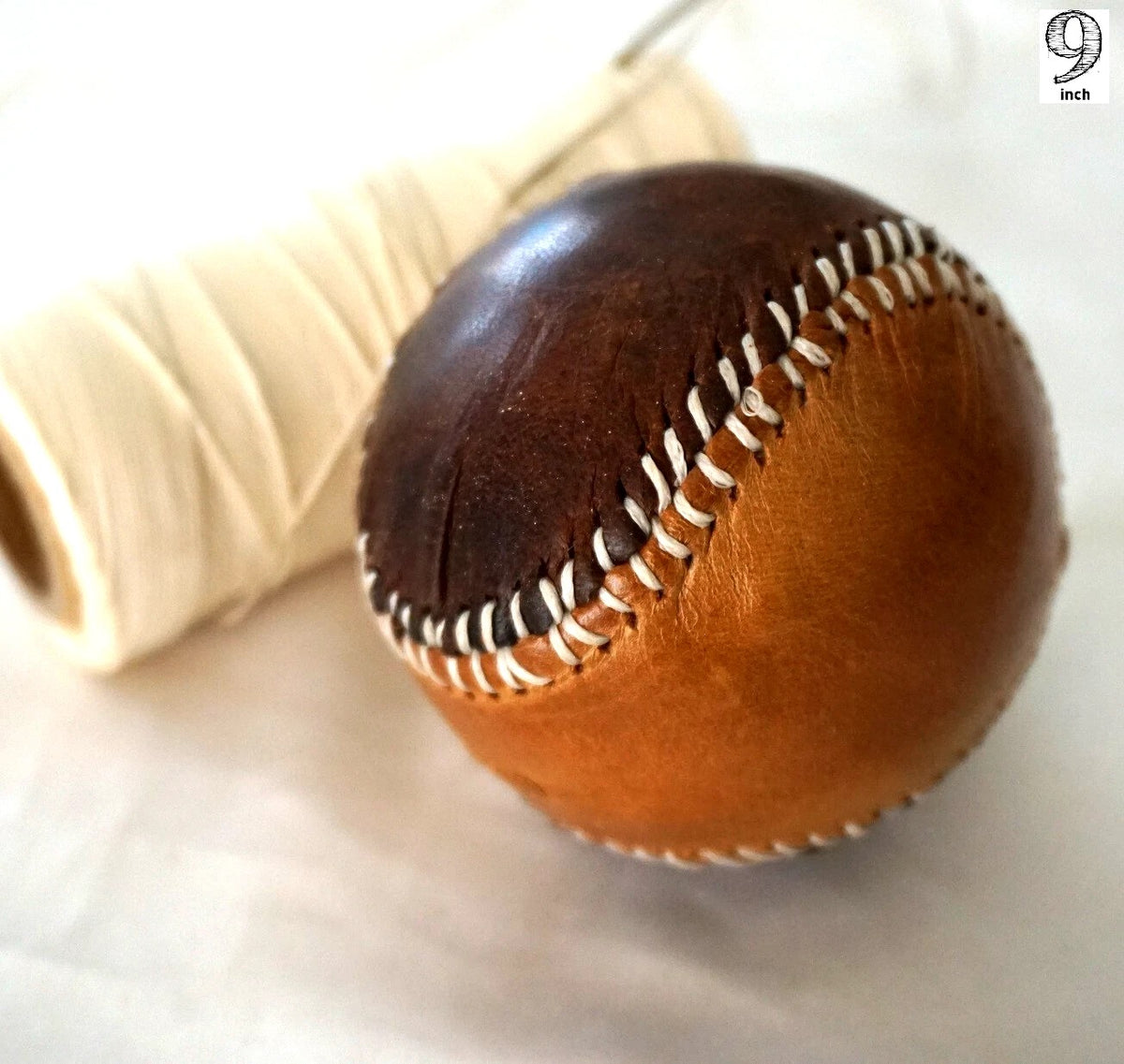 Handmade vintage red leather baseball with stitching, crafted with thread and needle by DAVISCASE.