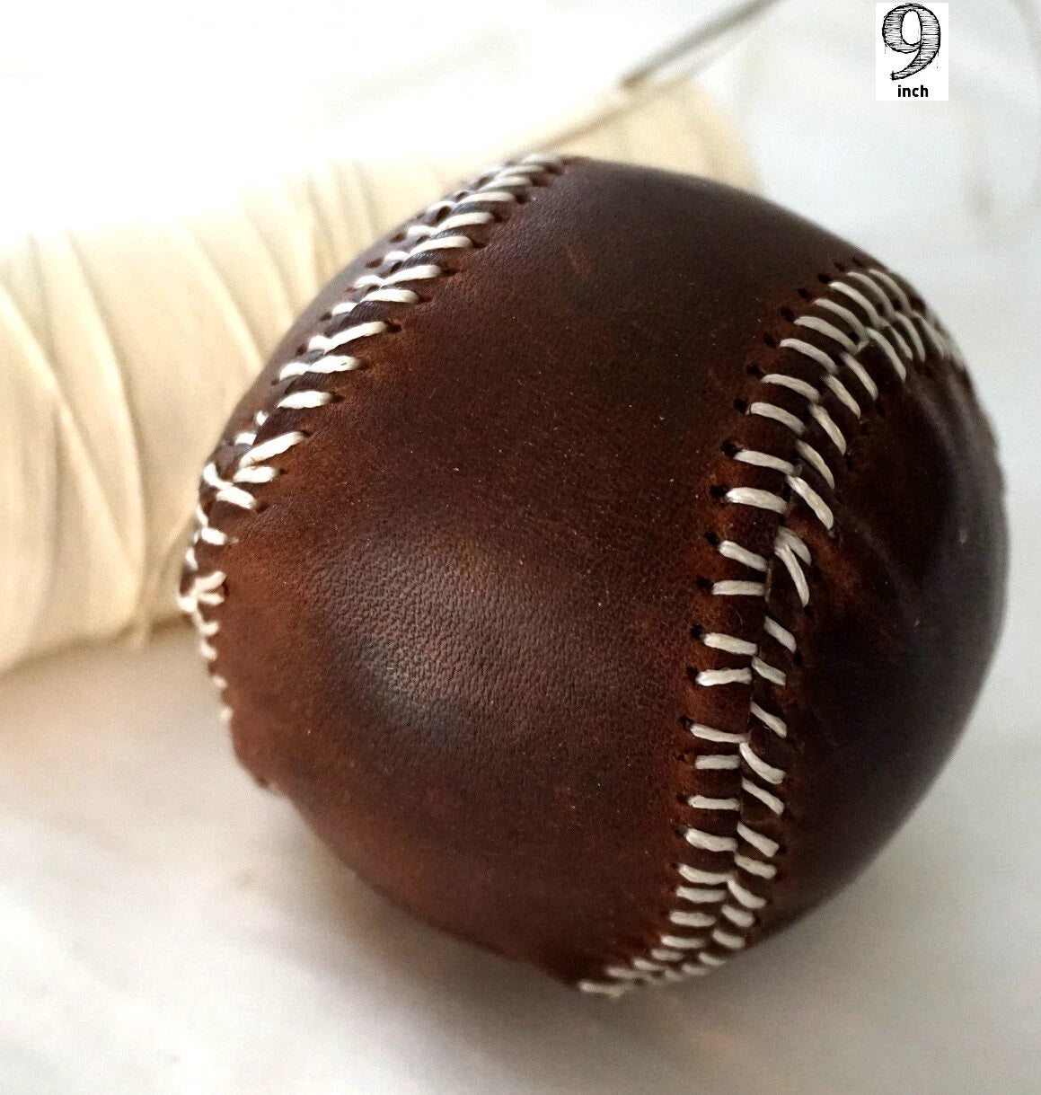Handmade vintage red leather baseball with stitching, created with thread and needle by DAVISCASE.