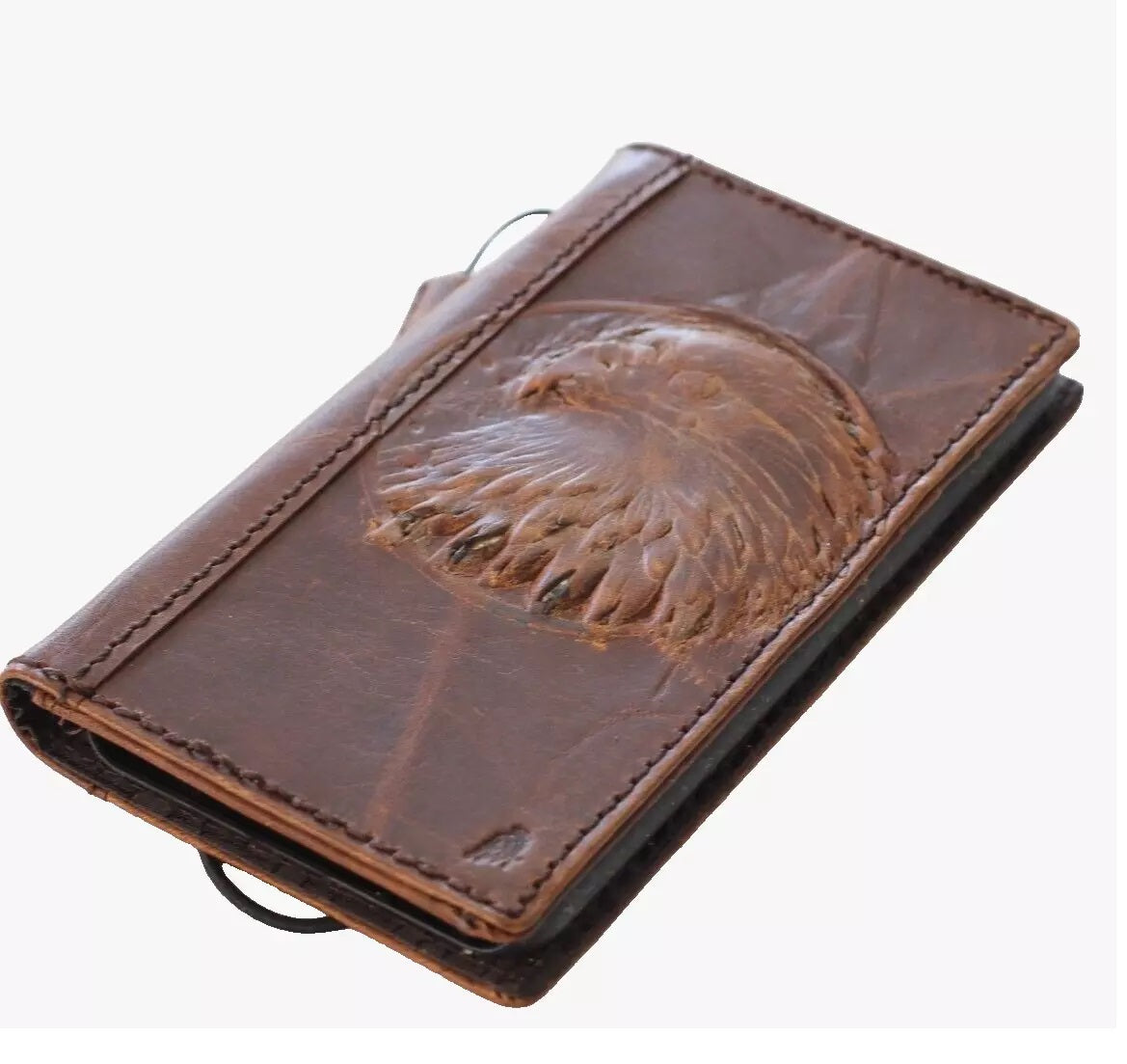 Handmade genuine leather phone case by DAVISCASE for iPhone models, with vintage eagle and falcon design, card slots, and wallet features.