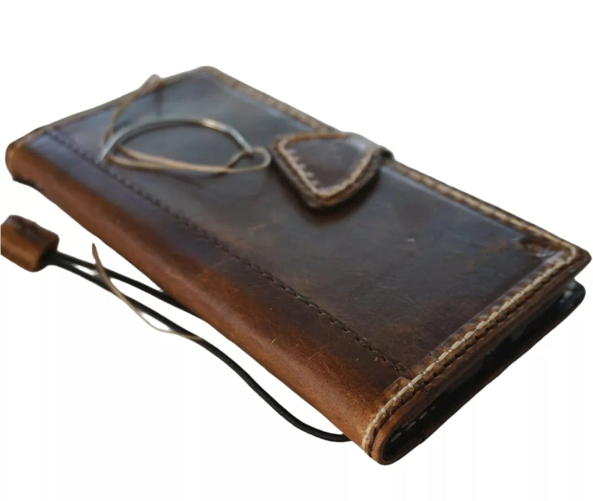 Handmade genuine leather wallet phone case for Apple iPhone models, featuring magnetic closure and sewn hand-oiled finish.