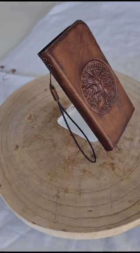 Handmade genuine leather phone case by DAVISCASE for iPhone 11 to 15, vintage style with Tree of Life design and magnetic closure.