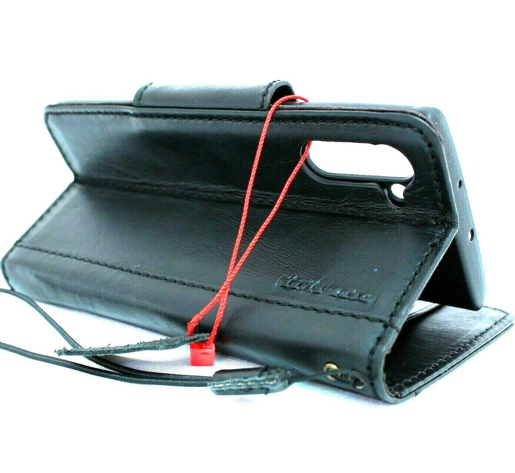 Black genuine leather Samsung Galaxy Note 10 wallet case with magnetic strap, window, and wireless charging compatibility.